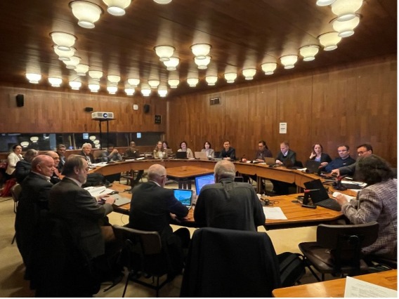 More than 20 global water and policy experts seated around a circular conference table in a wood-paneled meeting room.