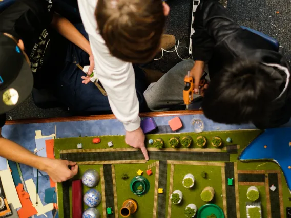 A view from above as three middle schools boys work on a Future City diorama project