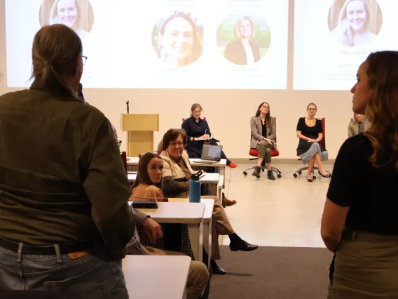 An audience member asks a question to panelists during the symposium.