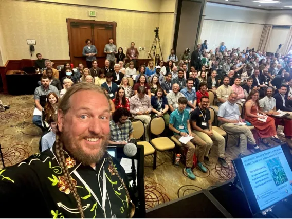 Barron-Gafford takes a selfie in front of a packed conference crowd.