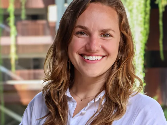 Gina Gilson smiles in a white collared shirt at the ENR2 building.