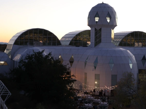 Biosphere 2 at sunset. String lights can be seen at the base of the building.