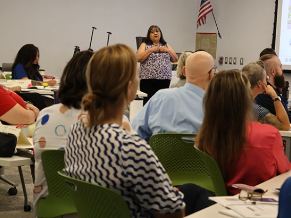 Joan Timeche delivers content at Native Know-How 2025, as seen from the back of the classroom with several seminar attendees in the foreground