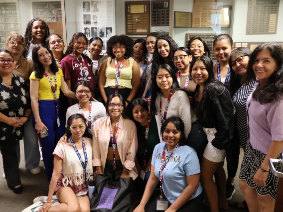 SUSI students pose with program manager Marcela Vasquez-Leon and NNI staff in front of a trophy case belonging to the U of A School of Journalism