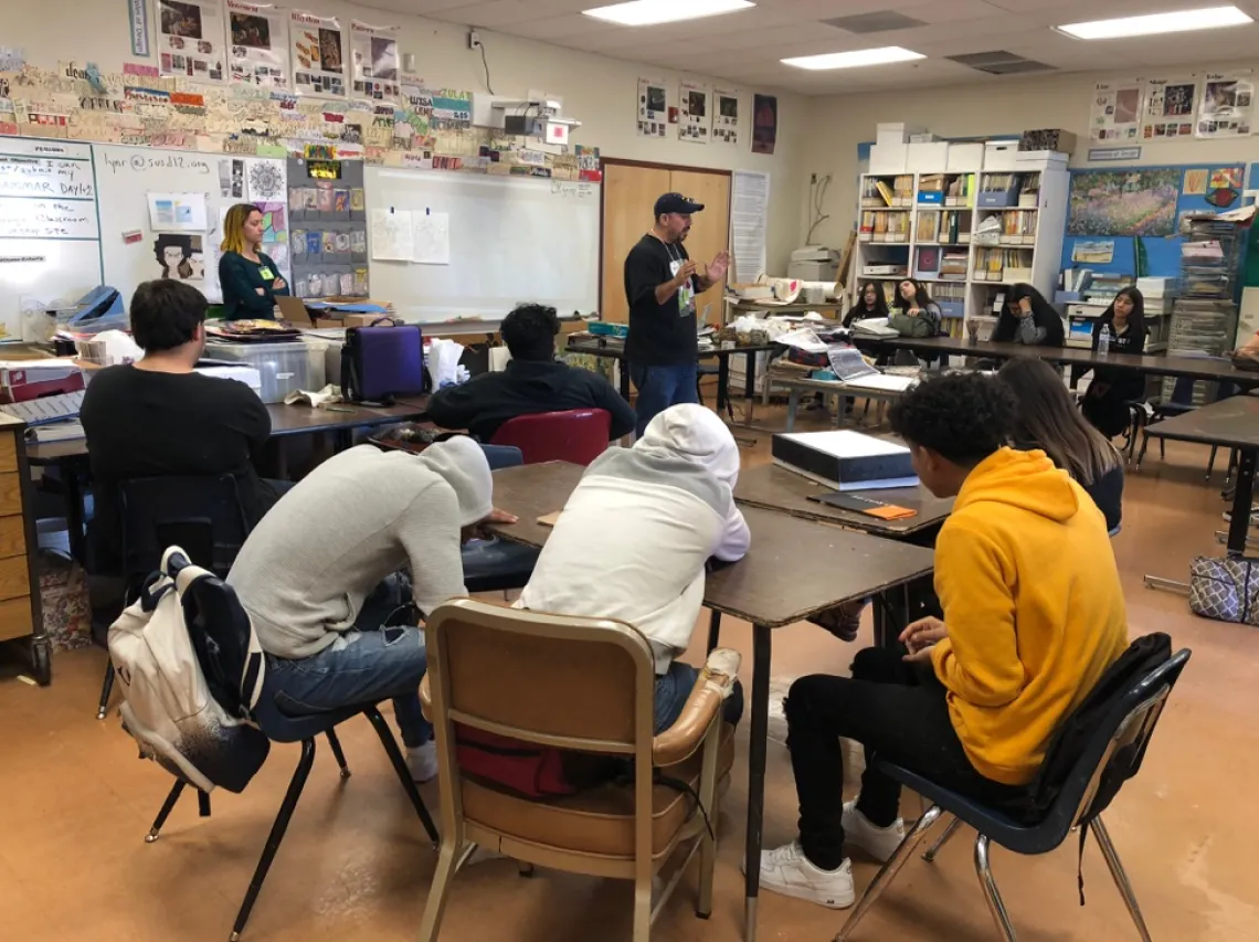 Local artist, Carlos Valenzuela, training high school students in mosaic work.