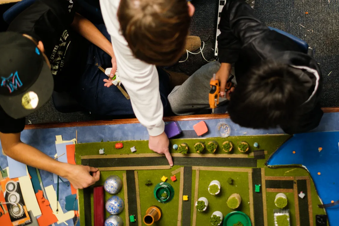 A view from above as three middle schools boys work on a Future City diorama project