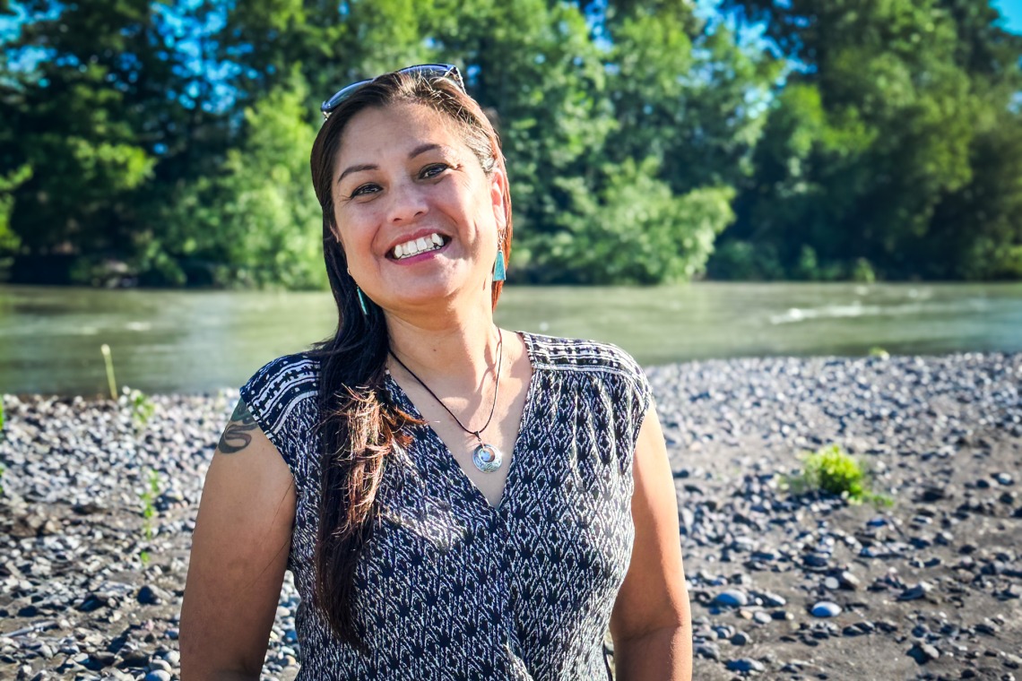 RaeAnna Rabang smiles in front of a river.