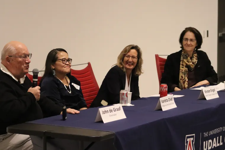 Filmmaker John de Graaf speaks into a microphone as panelists Karletta Chief, Kirsten Engel, and Katherine Morrissey look on during an expert panel discussion after the screening. 