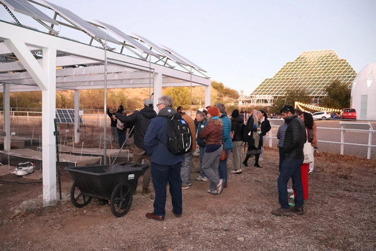 Guests examine an agrivoltaic research site at Biosphere 2