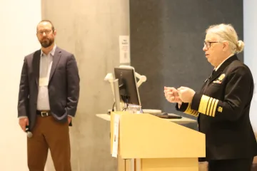 Admiral Rachel Levine in profile behind a podium as Udall Center Professor Ladd Keith looks on in the background.