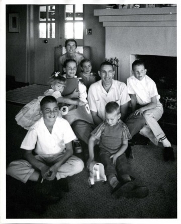 Mo Udall, his wife Pat, and six children pose in front of a fireplace.