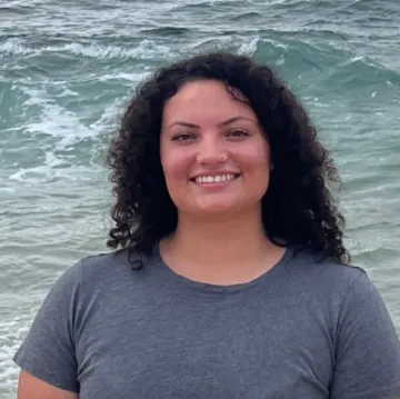 Portrait of Caitlin Brady in front of the ocean.