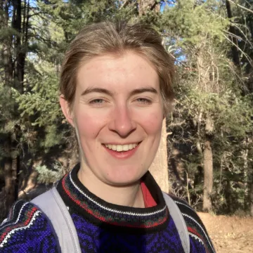 Selfie of Cara Buchanan in a pine forest.