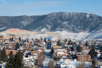Photo of Butte Montana in the winter with evidence of mining on the mountains in the background