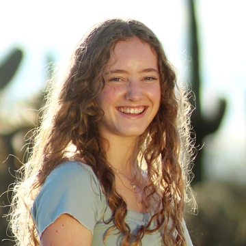 America Blackketter smiles with saguaro cacti out of focus behind her