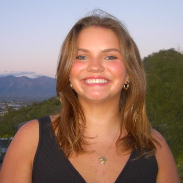 Brooke Aijala smiles on a mountain in southern Arizona at twilight