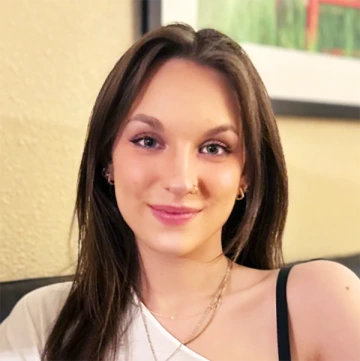 Lauren Clerihue poses for a selfie indoors with an abstract painting behind her