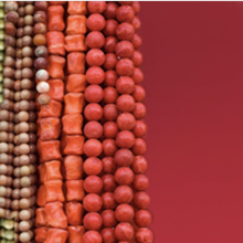 Strings of multi-colored beads cover the left side of the image over a dark-red background.