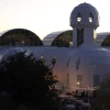 Biosphere 2 at sunset. String lights can be seen at the base of the building.